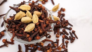 Kakule, karanfil, beyaz arka planda izole edilmiş karışık baharatlar. Tüm garam masala, Hint baharatları seçici odak.