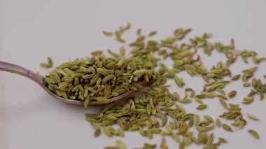 Beyaz arka planda izole edilmiş kuru rezene tohumu sesi. Bir yığın kuru rezene tohumu izole edilmiş görünüyor. Bir yığın kuru rezene tohumu, kaşığın içinde izole edilmiş gıdaların sesini çıkarıyor..