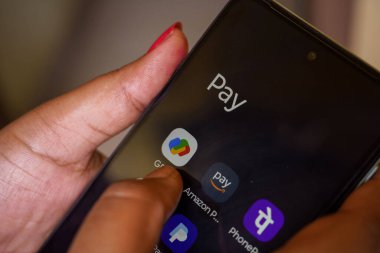Batı Bengal, Hindistan - 16 Mayıs 2025: UPI yoluyla Hindistan 'a uygulamayla para transferi. Google ödeme sistemi ve Amazon maaşı, telefon gibi diğer UPI uygulamalarını kullanan bir kadın.