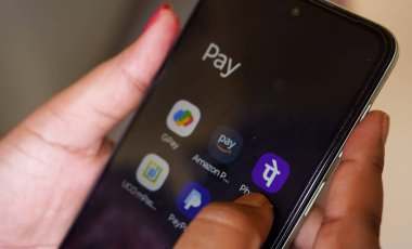 Batı Bengal, Hindistan - 16 Mayıs 2025: UPI yoluyla Hindistan 'a uygulamayla para transferi. Google ödeme sistemi ve Amazon maaşı, telefon gibi diğer UPI uygulamalarını kullanan bir kadın.