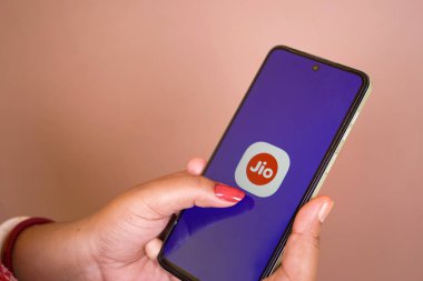 Jhargram, Batı Bengal, Hindistan - 16 Mayıs 2025: Akıllı telefon tutan bir kadın ve mobil ekranda benim jio uygulamam simgesi. Telefon uygulamasında mobil servis sağlayıcı.