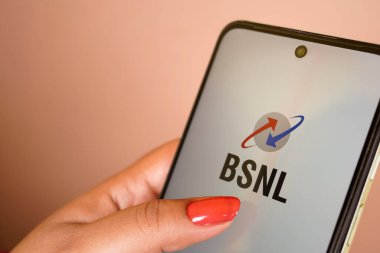 Batı Bengal, Hindistan - 16 Mayıs 2025: Hintli kadın elinde Hint firması Bharat Sanchar Nigam Limited 'in logosuyla cep telefonu tutuyor. Telefon ekranına odaklan.