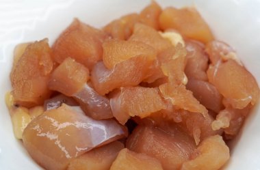 Kapatın ve seçici olarak beyaz arka planda izole edilmiş bir kase çiğ tavuk filetosuna odaklanın..