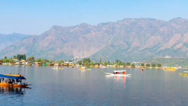 Srinagar, Jammu ve Kashmir, Hindistan; 11 Ekim 2024: Sonbahar mevsiminde Srinagar, Kashmir, Hindistan 'da dağ geçmişiyle Shikara tekne gezisinin güzel manzarası.