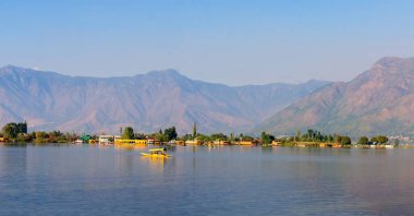 Srinagar, Jammu ve Kashmir, Hindistan; 11 Ekim 2024: Srinagar, Kashmir, Hindistan 'da yüzen yüzen tekneler ve dağ geçmişiyle Shikara' nın dal gölü üzerindeki güzel manzarası.