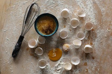 Hamur tatlısı yapmanın başlangıcı. Kırık yumurta ve un, hamuru yoğurmak için tahtanın üzerinde..