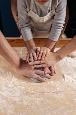 Aile elleri pizza ya da börek için hamur yapar. Anne, baba ve kızı birlikte yemek pişiriyor. Mutfaktaki takım..