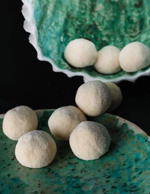 Siyah arka planda hazır peynirli krep topları.