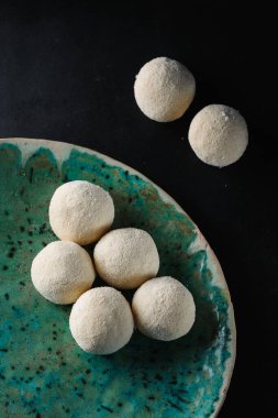 Siyah arka planda hazır peynirli krep topları.