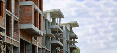 Monolitik ve kırmızı tuğladan yapılmış çok katlı bir bina.