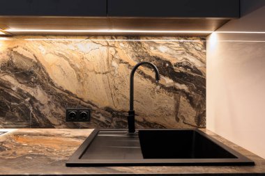 Black sink in the kitchen in a modern interior