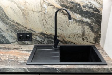Black sink in the kitchen in a modern interior