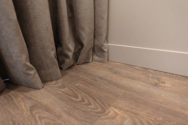Line of junction of laminate and plinth. Apartment interior.