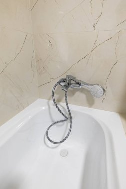 Acrylic bathtub in the bathroom interior in beige tones.