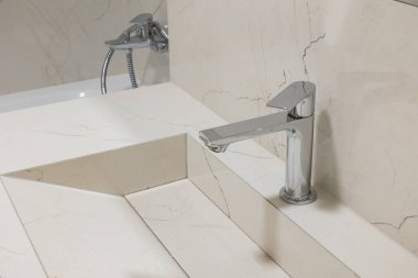 A faucet of steel color in a bathroom in a modern interior