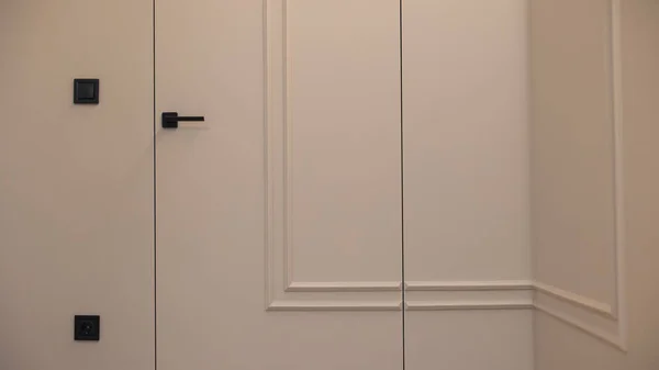 The door is built into the wall in the interior of a modern apartment