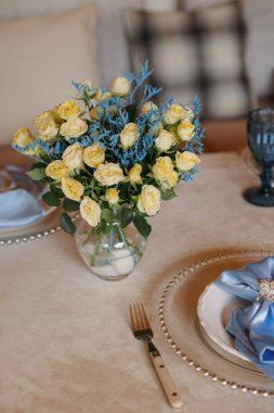 A table is set in a wooden gazebo near a house outside the city. Birthday decor.