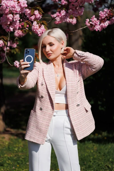 Beautiful Blonde Woman Smartphone Takes Photo Sun Rays Beige Background — Stock Photo, Image