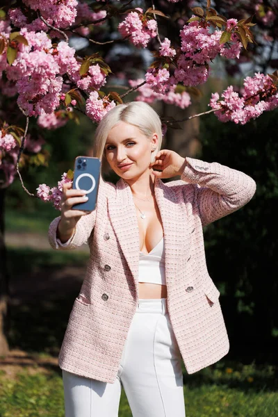 Een Mooie Blonde Poseert Recht Met Een Smartphone Die Foto — Stockfoto