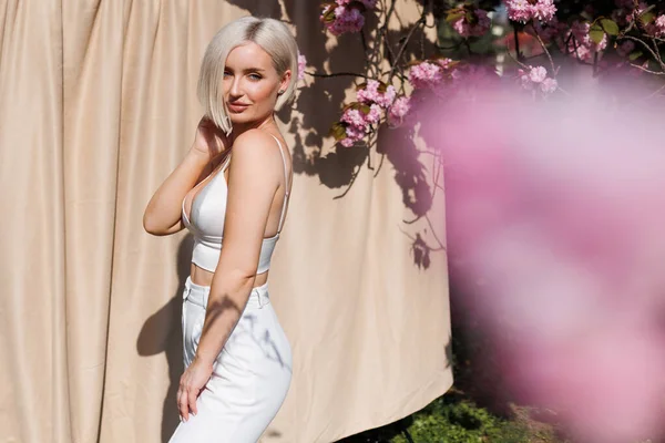 Bej tuval arka planında çiçek açan güzel bir kadın.