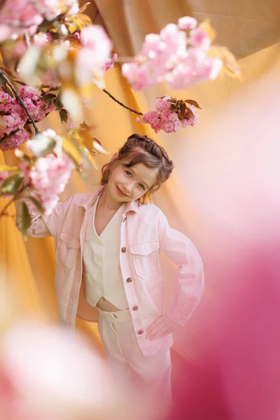 Egy Hangulatú Lány Bézs Háttérrel Virágzó Sakura Ággal — Stock Fotó
