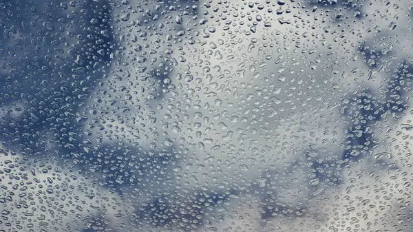 Regentropfen Auf Dem Glas Auf Dem Hintergrund Eines Blauen Bewölkten — Stockfoto
