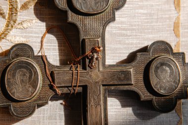 Eski Kutsal Büyük Haç 'ın arka planında bir çocuğun vaftiz töreni için küçük bir haç. Kilise aletleri..