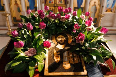 Güzel bir ikonostaz, kilisede tatil sırasında pembe lalelerle süslenir. Kilisedeki masada İsa 'nın ikonu..