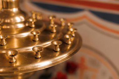 Pek çok mum için altın kilise şamdanının yakın çekimi. Kilise aletleri..