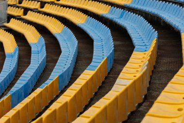 Ukrayna stadyumunun futbol sahasındaki mavi ve sarı koltuklar. Hayranlar için koltuklar