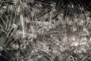 Plastik şişelerin üretimi için toplanmış PET ön form boşluklarına yakından bakın.
