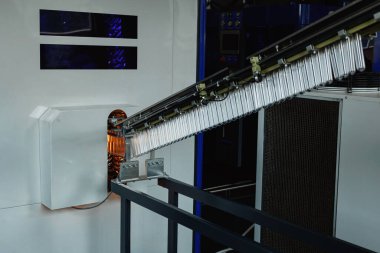 Son model konveyör hattı ısıtma ve şişirme kullanarak küçük boşluklardan boş plastik şişeler yaratıyor.
