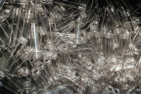 Plastik şişelerin üretimi için toplanmış PET ön form boşluklarına yakından bakın.