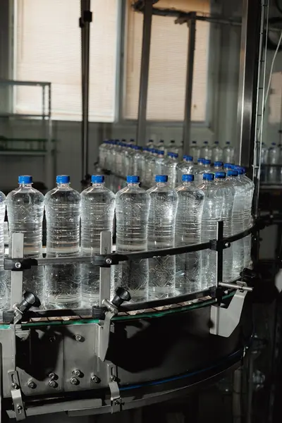 Plastic bottles filled with pure water moving on the assembly line.