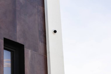 Modern güvenlik kameraları stratejik olarak bir binanın köşesine yerleştirilmiş, kentsel çevreyi dikkatle izliyorlar..