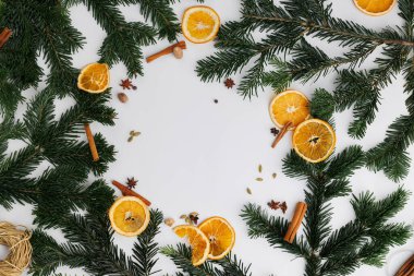 Güzel düzenlenmiş bir çemberde Noel ağacı, kurutulmuş portakal, tarçın, kakule ve yıldız anason ile yılbaşı tılsımı sergileniyor..