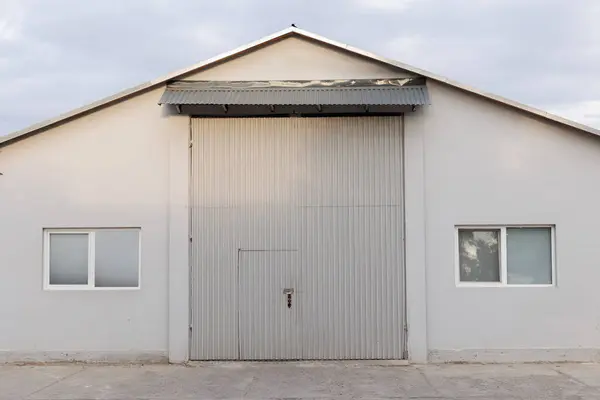 Endüstriyel depolama veya depolama amaçlı geniş bir alan sunan yüksek tavanlı geniş bir hangar.