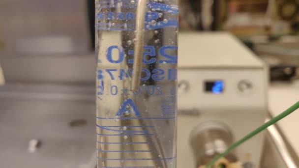 教育目的で化学研究室のシリンダーを測定する有機溶媒を介して窒素バブル 有機層における二酸化炭素の泡の効果 4K科学的背景概念 — ストック動画