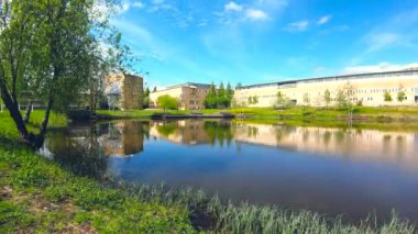 4K moving timelapse of cloud movement on sky beside a cityscape water pond.