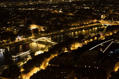 High Resolution Panorama Of Paris Skyline from Eiffel Tower during rainy sunset. Night time light from the city roads and buildings.