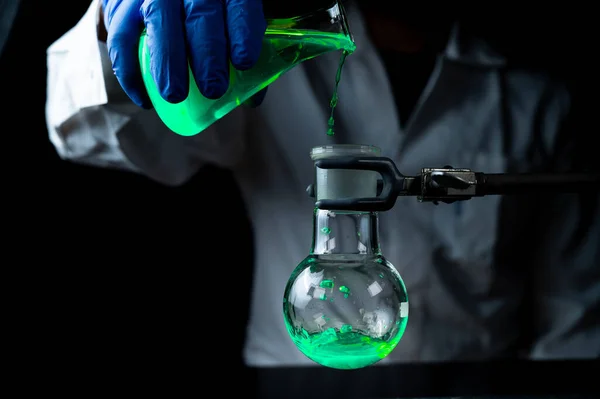 과학자가 발전을 어두운 실험실에 플라스크에서 용액을 가지고 실험을 있습니다 스페이스 — 스톡 사진