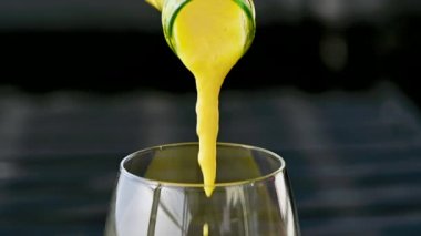 Koyu arkaplanda taze meyve, nane ve saman bulunan cam bir şişedeki tropikal mango lassi smoothie 'yi yavaş çekimde kopyalama alanı ile tazeliyorum..