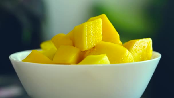 热带芒果方块在一个白色的碗里 用新鲜的水果和薄荷装饰在黑暗的背景中 并带有复制空间 让它焕然一新 — 图库视频影像