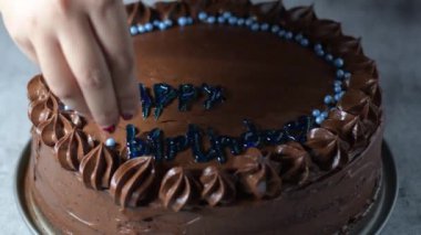 Kadın fırıncı elleri çikolatalı kek pastasını masanın üzerine çikolatalı kremayla süsler. 4K, kopyalama alanını kapat Alan derinliği.