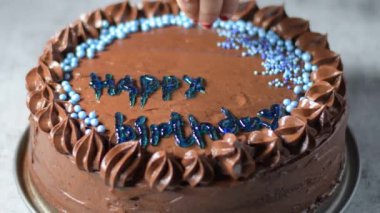 Kadın fırıncı elleri çikolatalı kek pastasını masanın üzerine çikolatalı kremayla süsler. 4K, kopyalama alanını kapat Alan derinliği.