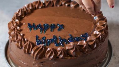 Kadın fırıncı elleri çikolatalı kek pastasını masanın üzerine çikolatalı kremayla süsler. 4K, kopyalama alanını kapat Alan derinliği.