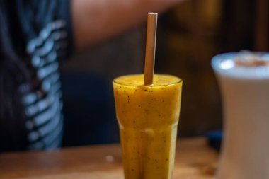 Mango meyveli ve arka planlı lezzetli sulu smoothie. Uzayı kopyala Pop sanat tasarımı, yaratıcı yaz konsepti. Cam şişelerde taze meyve suyu..