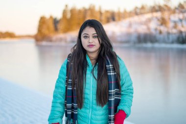  Renkli ceketli güzel bir kadının portresi. Siyah ceketli güzel bir kadın Sihirli Kış Ormanı 'nda yürüyor. Bulutlu gökyüzü ile doğal manzara. 