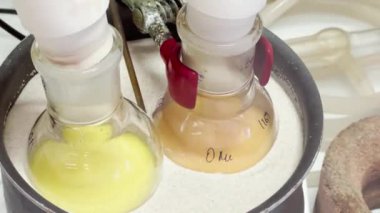 Kum banyosunda rengarenk tepkiler. Kimya laboratuvarında 4K video deneyleri. Laboratuvarda biyokimyasal tıp sentezi.