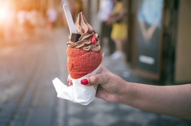 Trdelnik ya da trdlo geleneksel Çek tatlısıdır. Prag caddesinde Trdlo 'yu elinde tutan bir kadın. Sokak yemeği. Trdelnik şeker ve tarçınlı geleneksel tatlı bir pasta.